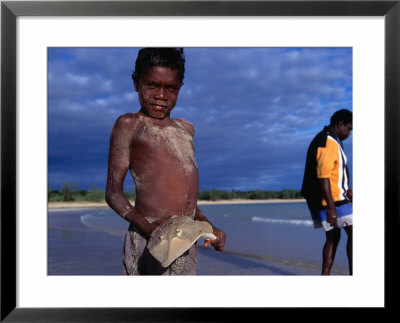 Young Aboriginal Boy With Shovel Nose Fish, Aurukun, Cape York Peninsula, Queensland, Australia by Oliver Strewe Pricing Limited Edition Print image