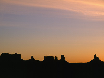 Sunset Silhouettes The Jagged Buttes And Ridges Of Monument Valley by Stephen St. John Pricing Limited Edition Print image