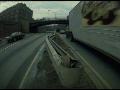 Twisted Guardrail Evidencing Prior Accident Separating Traffic On Walled-In Urban Highway by Ralph Crane Pricing Limited Edition Print image