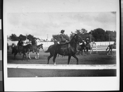 A Female Rider Surrounded By Men On Horseback During Buffalo Bill's Wild West Show by Wallace G. Levison Pricing Limited Edition Print image