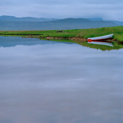 Still Lake, Reflection And Boat In Grass, Mountains And Fog In Background by Jon Pall Vilhelmsson Pricing Limited Edition Print image