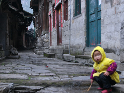 Child Playing On The Street, China by Ryan Ross Pricing Limited Edition Print image