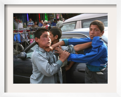 Two Afghan Children Who Are Making Car Washing Work Fight Kabul, Afghanistan, June 29, 2006 by Rodrigo Abd Pricing Limited Edition Print image