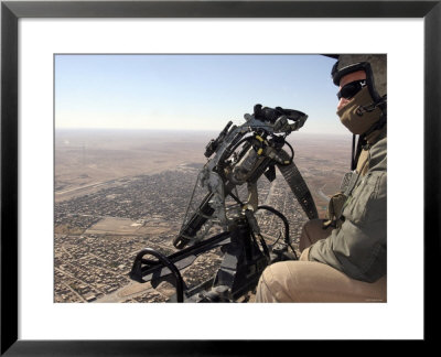 A Crew Chief Looks Out For Suspicious Activity While Manning A Helicopters Machine Gun by Stocktrek Images Pricing Limited Edition Print image