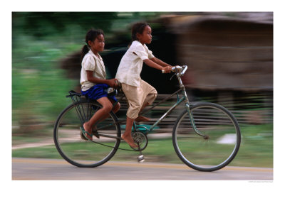 Young Girls Riding Bikes To The Village School In Bavel, Battambang, Cambodia by Jerry Galea Pricing Limited Edition Print image