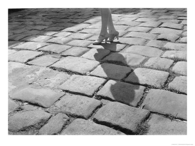 A Lady In High Heels Walks Along A Cobblestoned Street by Edwin L. Wisherd Pricing Limited Edition Print image