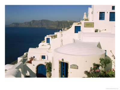 Houses With Blue Doors And Window Frames Overlook The Aegean Sea by Mark Cosslett Pricing Limited Edition Print image