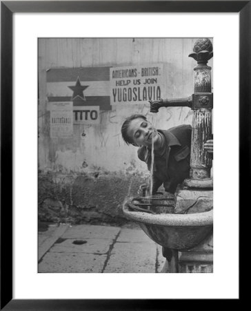 Young Boy Getting A Drink From Fountain In Trieste Region by Nat Farbman Pricing Limited Edition Print image