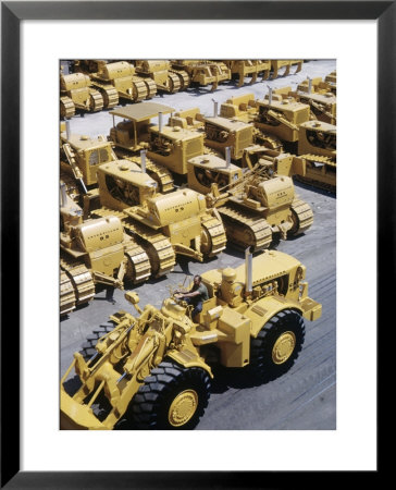 Rows Of Brightly Colored Caterpillar Bulldozers Lined Up At An Unidentified Factory by John Zimmerman Pricing Limited Edition Print image