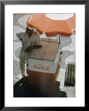 Coca-Cola Vendor Leaning On Cart With Umbrella On Mosaic Sidewalk, Copacabana Beach, Rio De Janeiro by Dmitri Kessel Pricing Limited Edition Print image