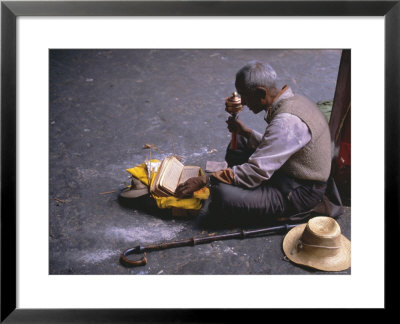 Tibetan Buddhist Pilgrim Reading Texts And Holding Prayer Wheel, Lhasa, China by Alison Wright Pricing Limited Edition Print image