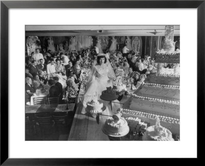 At Palumbo's Cafe, Bride Mrs. Salvatore Cannella Walks Onto Stage, Facing A Revolving Cake Display by Cornell Capa Pricing Limited Edition Print image