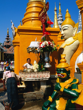 People Making Offerings Amongst The Statues Of Deities At The Base Of Shwedagon Paya, Myanmar by Juliet Coombe Pricing Limited Edition Print image