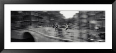 Rear View Of Three People Cycling, Amsterdam, Netherlands by Panoramic Images Pricing Limited Edition Print image