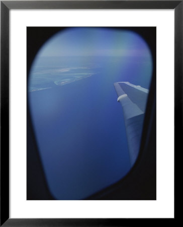 A View Out Of An Airplane Window Over Water And Nearby Islands by Roy Gumpel Pricing Limited Edition Print image