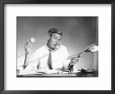 Man Working Hard With Two Telephones by Ewing Galloway Pricing Limited Edition Print image