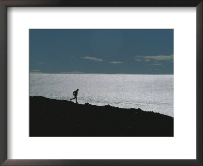 Silhouette Of Man Jogging Past A Bare Glacier Below Patriot Hills by Gordon Wiltsie Pricing Limited Edition Print image