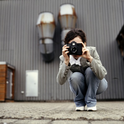 A Young Woman Crouching And Taking A Photograph by Jewgeni Roppel Pricing Limited Edition Print image