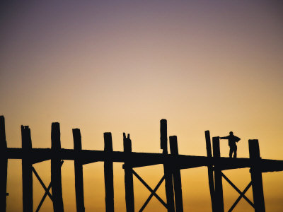 Man Standing On The U Bein Bridge At Sunset In Mandalay, Burma by Scott Stulberg Pricing Limited Edition Print image