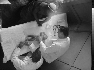 Milton Goldrath, Junior Medical Student, With Another Student Examining A Baby by Alfred Eisenstaedt Pricing Limited Edition Print image