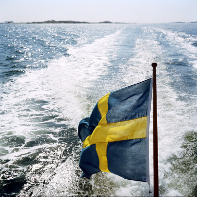The Swedish Flag On A Ferry Sailing In The Gateborg Archipelago, Sweden by Maria Olsson Pricing Limited Edition Print image