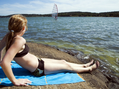 Side Profile Of A Woman Sunbathing At The Coast, Erstavik, Sweden by Inger Bladh Pricing Limited Edition Print image
