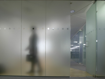 Office Life And Interiors, Glass Partition And Figure Walking Behind It by Richard Bryant Pricing Limited Edition Print image