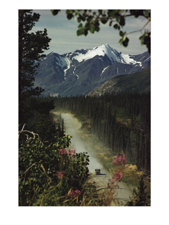 A Camper Rolls Down A Dirt Road Below High Mountains In Alaska by W. E. Garrett Pricing Limited Edition Print image