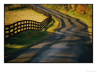 Twilight View Of A Wooden Fence And Its Shadow Along A Country Road by Kenneth Garrett Pricing Limited Edition Print image