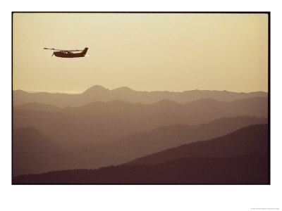 An Aircraft Flies Over A Mountainous Landscape by Joel Sartore Pricing Limited Edition Print image