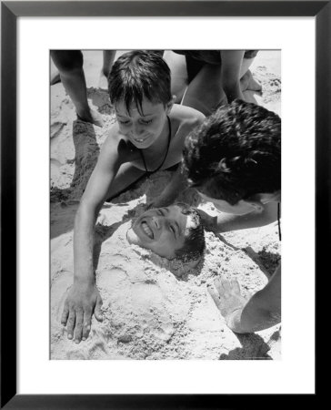 Settlement House Children Burying Boy Under Sand At The Beach by Martha Holmes Pricing Limited Edition Print image
