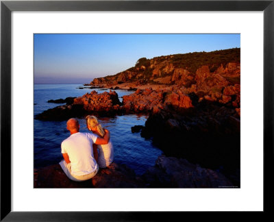 Couple Enjoying Sunset On Rocky Coastline At Hovs Hallar, Hovs Hallar Nature Reserve, Skane, Sweden by Anders Blomqvist Pricing Limited Edition Print image