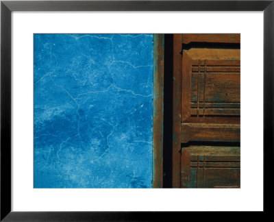 Blue Wall Stands In Stark Contrast To An Old Wooden Door by David Evans Pricing Limited Edition Print image
