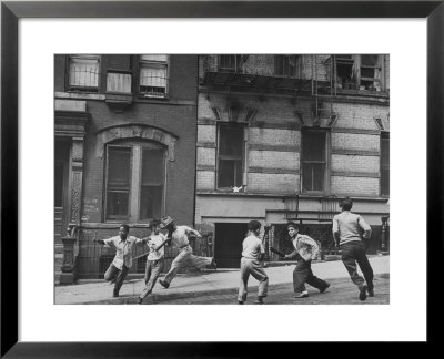 Young Boys With Sticks, Running Around While Playing A Street Game In Spanish Harlem by Ralph Morse Pricing Limited Edition Print image