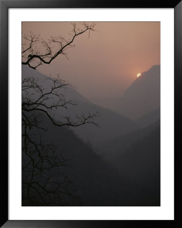 Sunlight Cuts Through Fog Filling A Mountain Valley At Twilight by Jodi Cobb Pricing Limited Edition Print image