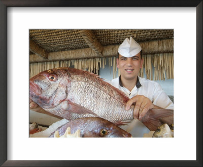 A Restaurant Worker Selects A Fish To Prepare For A Meal by Richard Nowitz Pricing Limited Edition Print image