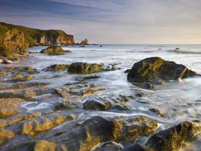 Late Evening Sunlight Glows On Weathered Rock Ledges At Bantham In South Devon, England by Adam Burton Pricing Limited Edition Print image