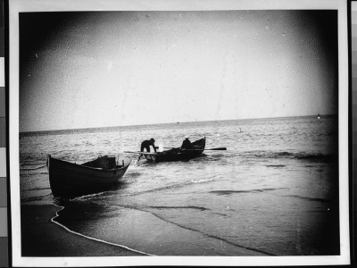 Two Fishermen Getting Their Rowboat Out To Sea, As Other Boat Rests Near Shore by Wallace G. Levison Pricing Limited Edition Print image