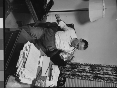 Writer Damon Runyon Sitting At His Desk Piled With Papers by Gjon Mili Pricing Limited Edition Print image