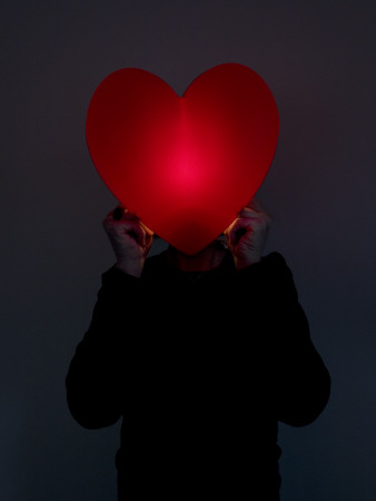 Close-Up Of A Person Holding A Heart Shape Object In Front Of His Face by Jan Nordstrom Pricing Limited Edition Print image