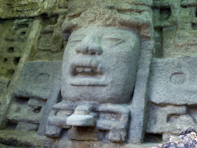 Large Stone Head In Mayan Ruin Of Lamani In Belize by Stephen Sharnoff Pricing Limited Edition Print image