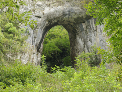 Natural Rock Arch Leading To Reynards Cave, Dovedale, Peak District Np, Derbyshire, Uk by Gary Smith Pricing Limited Edition Print image