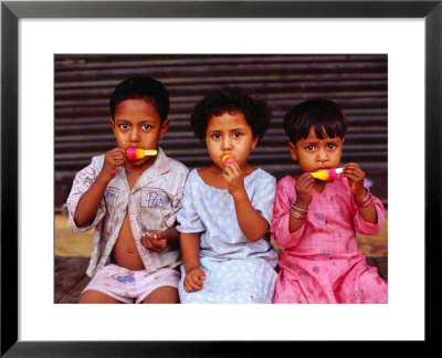 Three Children Eating Icy-Poles, Bengali Basti, Delhi, India by Daniel Boag Pricing Limited Edition Print image