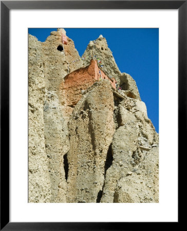 Looking Up At A Buddhist Cave Monastery In Mustang, Nepal by Stephen Sharnoff Pricing Limited Edition Print image