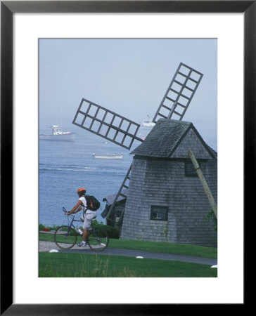 Bicyclist Rides Past A Windmill On A Cape Cod Shore, Chatham, Massachusetts by Darlyne A. Murawski Pricing Limited Edition Print image