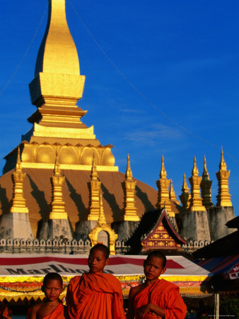 Three Young Monks Standing In Front Of Pha That Luang, Vientiane, Vientiane Prefecture, Laos by Alain Evrard Pricing Limited Edition Print image