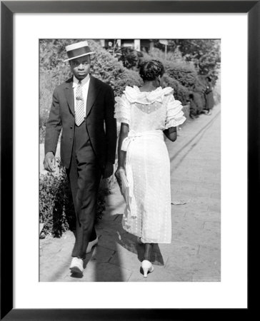African American Sporting His Sunday Finery Glancing At Frilly Frocked Girl Passing Him On Street by Alfred Eisenstaedt Pricing Limited Edition Print image