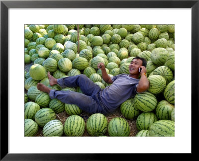 A Man Talks On His Phone Under The Shade Of His Watermelon Stall, Savannakhet, Laos, Indochina by Andrew Mcconnell Pricing Limited Edition Print image