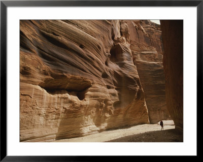A Hiker Is Dwarfed By The Sandstone Walls Of A Utah Canyon by Dugald Bremner Pricing Limited Edition Print image