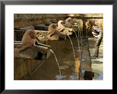 Girl Takes A Drink From The Water Spouts In A Temple Courtyard At Godavari In The Kathmandu Valley by Don Smith Pricing Limited Edition Print image